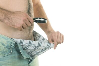 Um homem olha para seu pênis, querendo aumentar seu tamanho